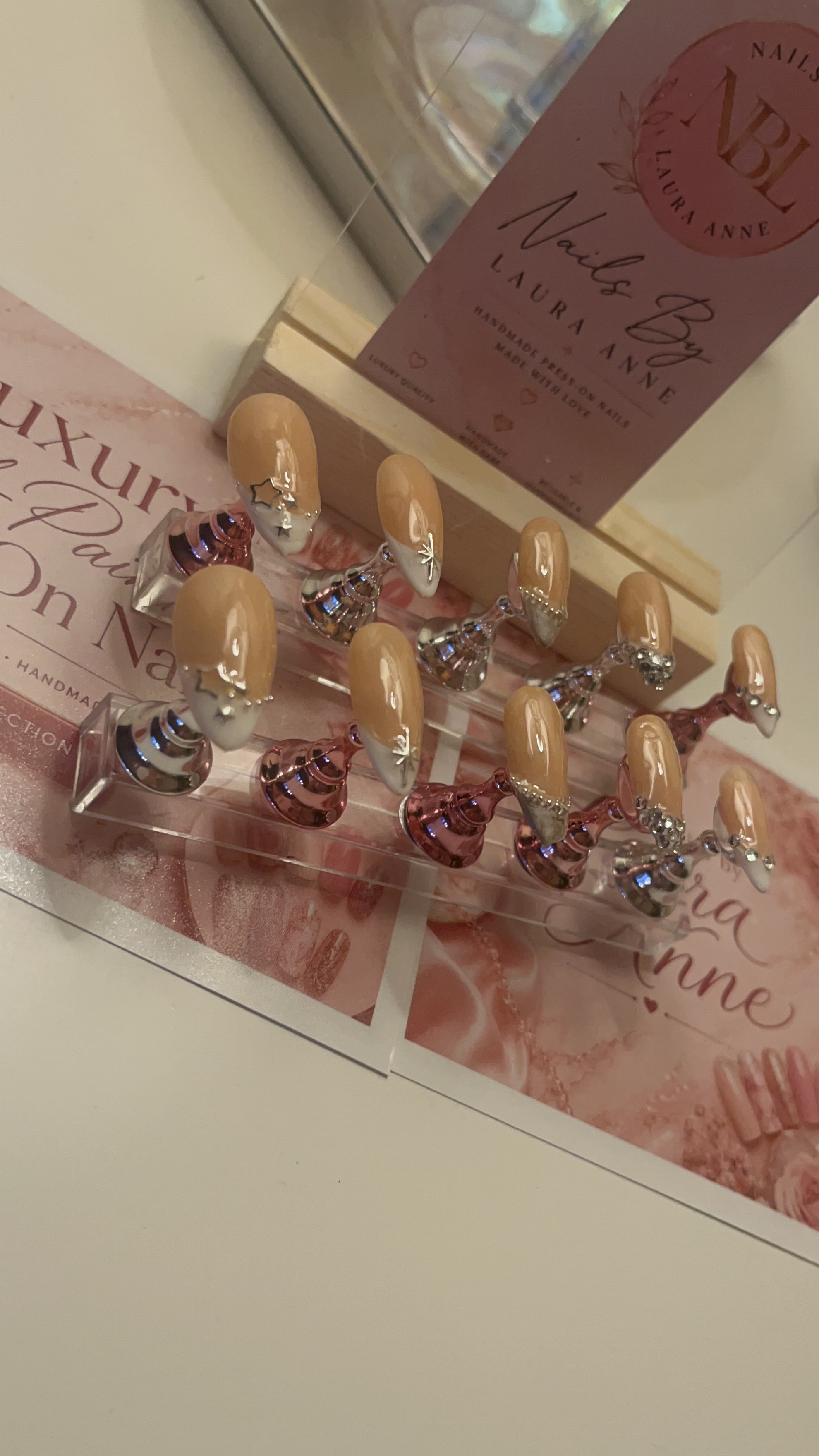 Glossy nude press-on nails with hand-painted gold wave details